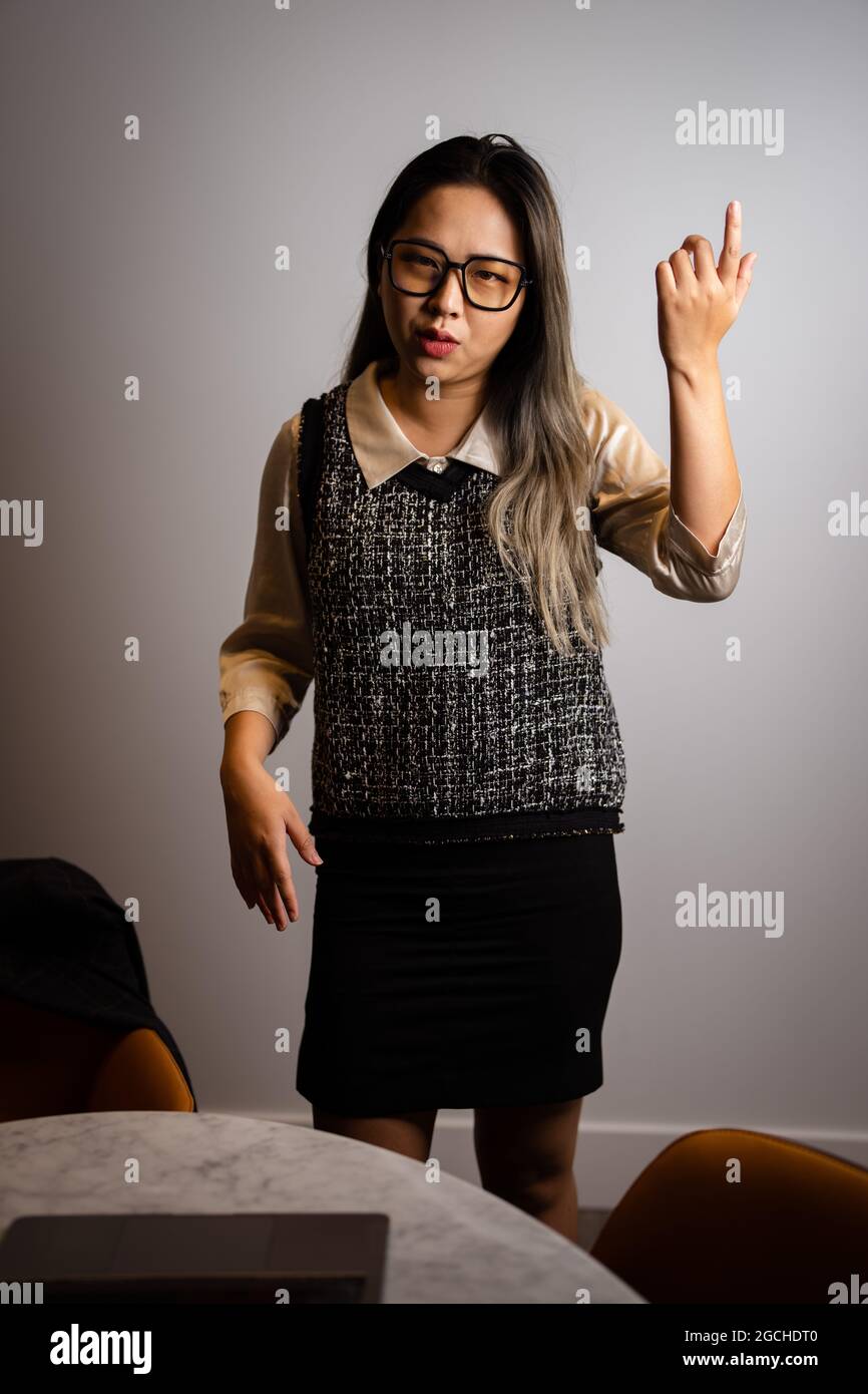 Giovane scienziata asiatica di dati che presenta i dati di analisi in una sala conferenze Foto Stock