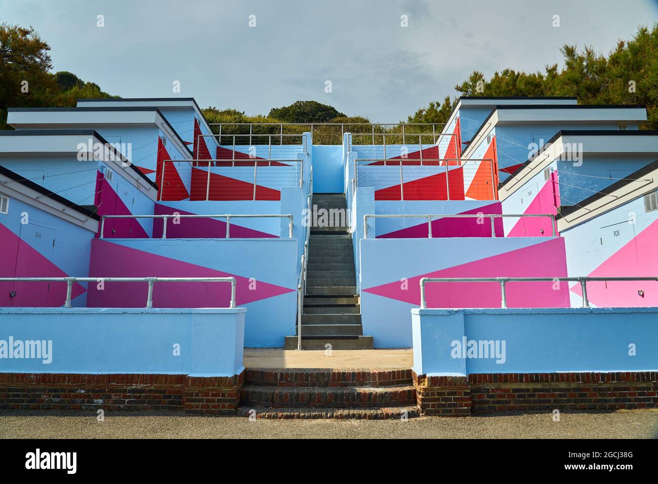 Edificio astratto in cemento blu e rosa con alberi sullo sfondo Foto Stock