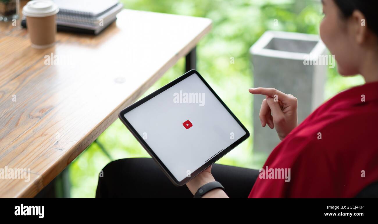 CHIANG mai, THAILANDIA - 01 AGOSTO 2021 : Donna mano tenendo e sta premendo lo schermo di YouTube su Apple tablet digitale, YouTube è il popolare online Foto Stock