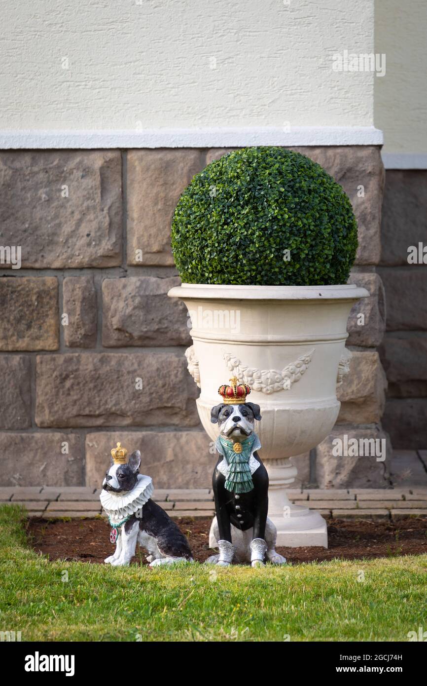 Due cani scolpiti che sorvegliano un giardino anteriore in Germania Foto Stock