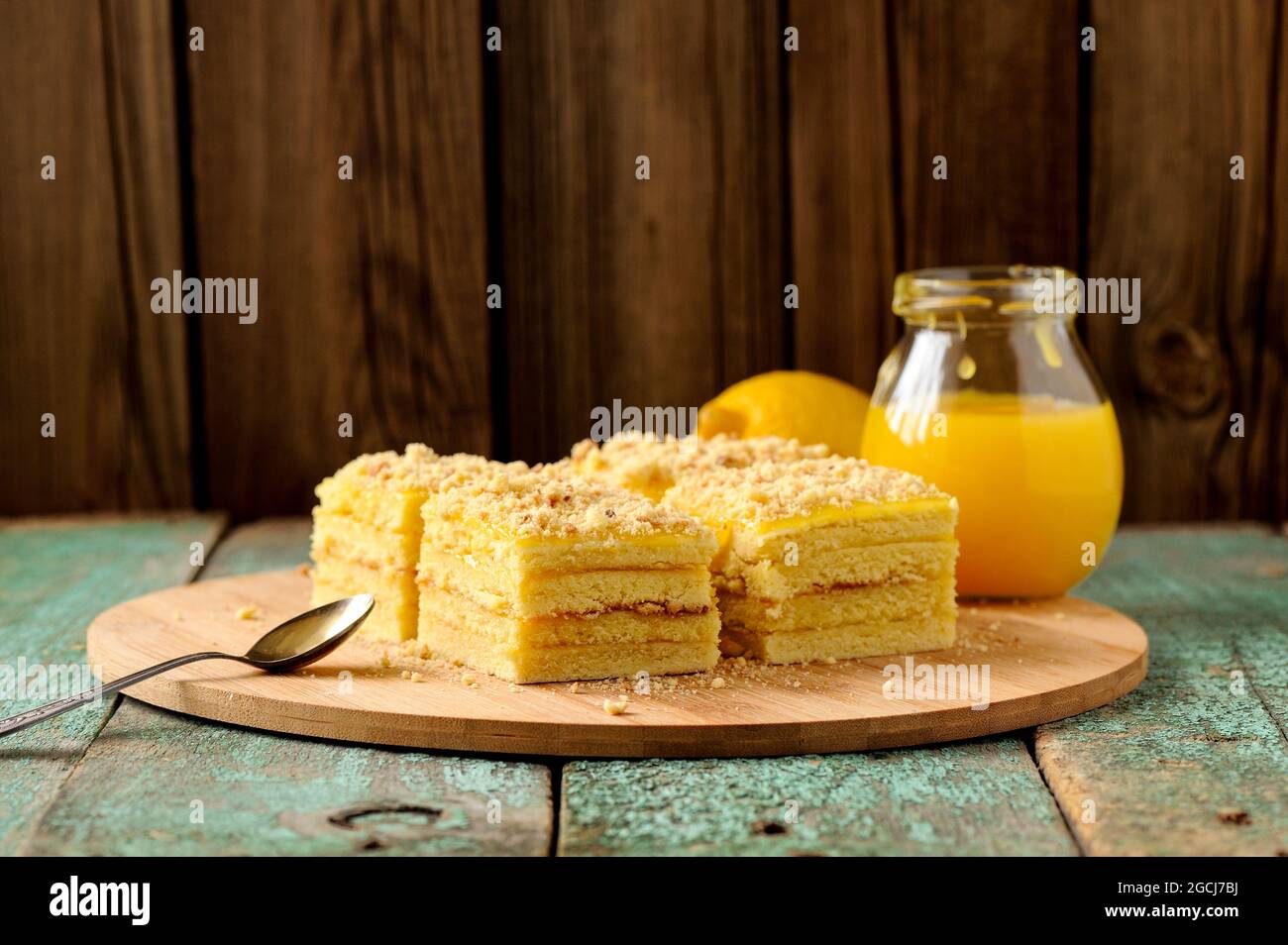 Torta di limone a strati di yummy fatta in casa servita con tè e cagliata di limone su piatto di bambù con copyspace Foto Stock