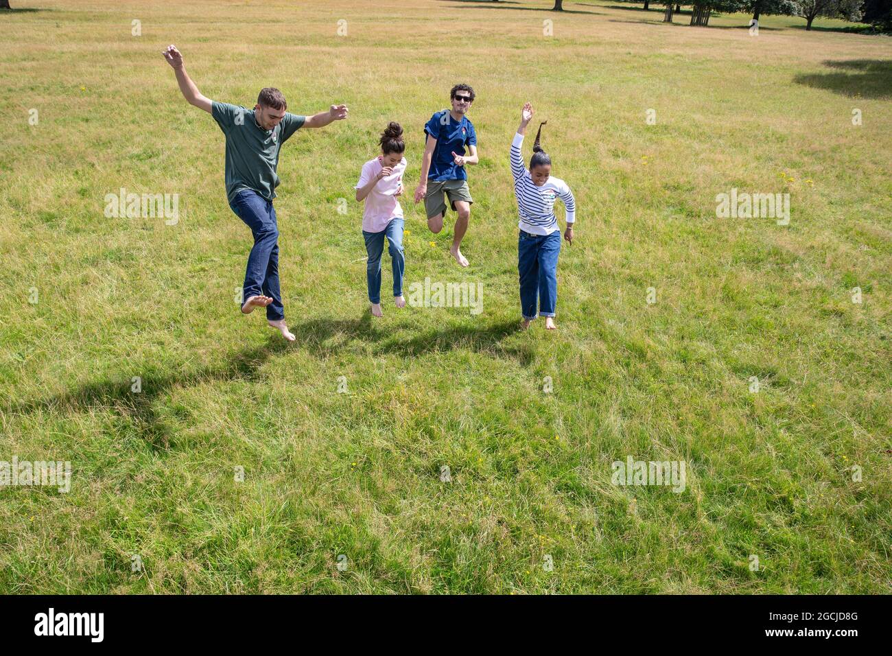 Un gruppo di giovani corre e salta nel parco. Foto Stock
