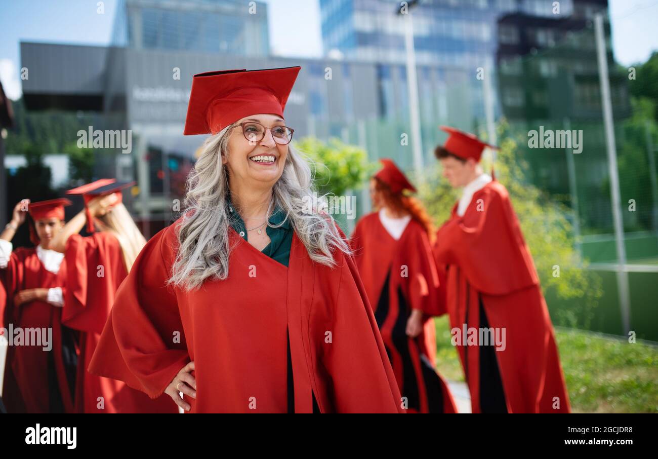 Ritratto di allegra studentessa anziana all'aperto, laurea e terzo concetto universitario di età. Foto Stock