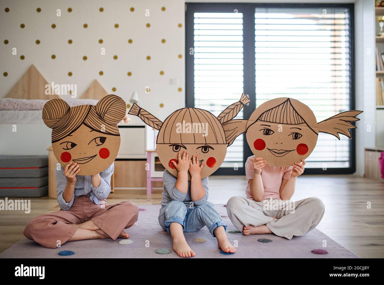 Ritratto di tre sorelle ragazze in casa, giocando. Foto Stock