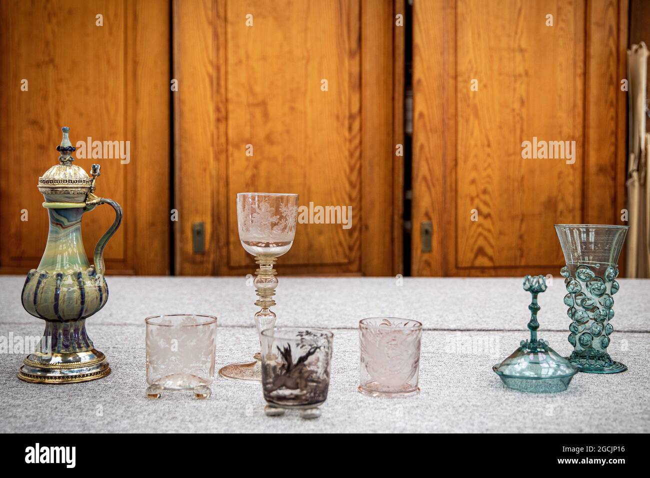 Duesseldorf, Germania. 09 agosto 2021. Una brocca a coste (l-r) di vetro di agata un becher con aquila imperiale e stemma della città di Norimberga, un calice di balaustra cavo con allegorie di autunno e inverno, un becher con una rappresentazione di una caccia par force, becher con trofei di vittoria e un becher a piedi con coperchio, nouches soffiati e decorazione del filo. Il Museo Kunstpalast ha ricevuto indietro preziosi bicchieri vecchi che erano stati rubati nel 2000. Credit: Mante Krudewig/dpa/Alamy Live News Foto Stock