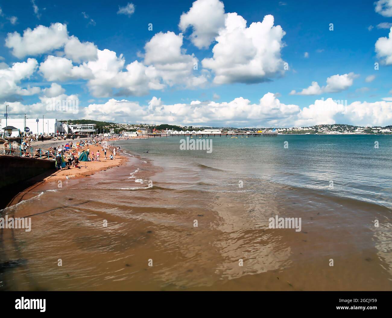 Una soleggiata giornata estiva alla spiaggia di Paignton sulla 'Riviera Inglese' Torbay, South Devon, Inghilterra sudoccidentale, completa di vacanzieri sulla sabbia mentre o Foto Stock