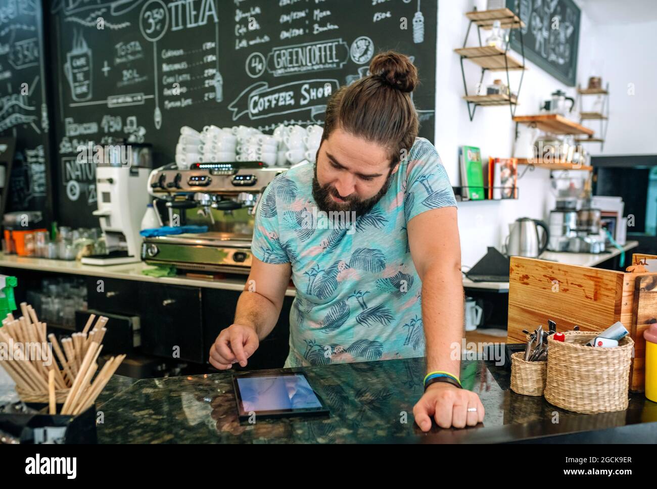 Il proprietario della caffetteria esamina i conti commerciali Foto Stock
