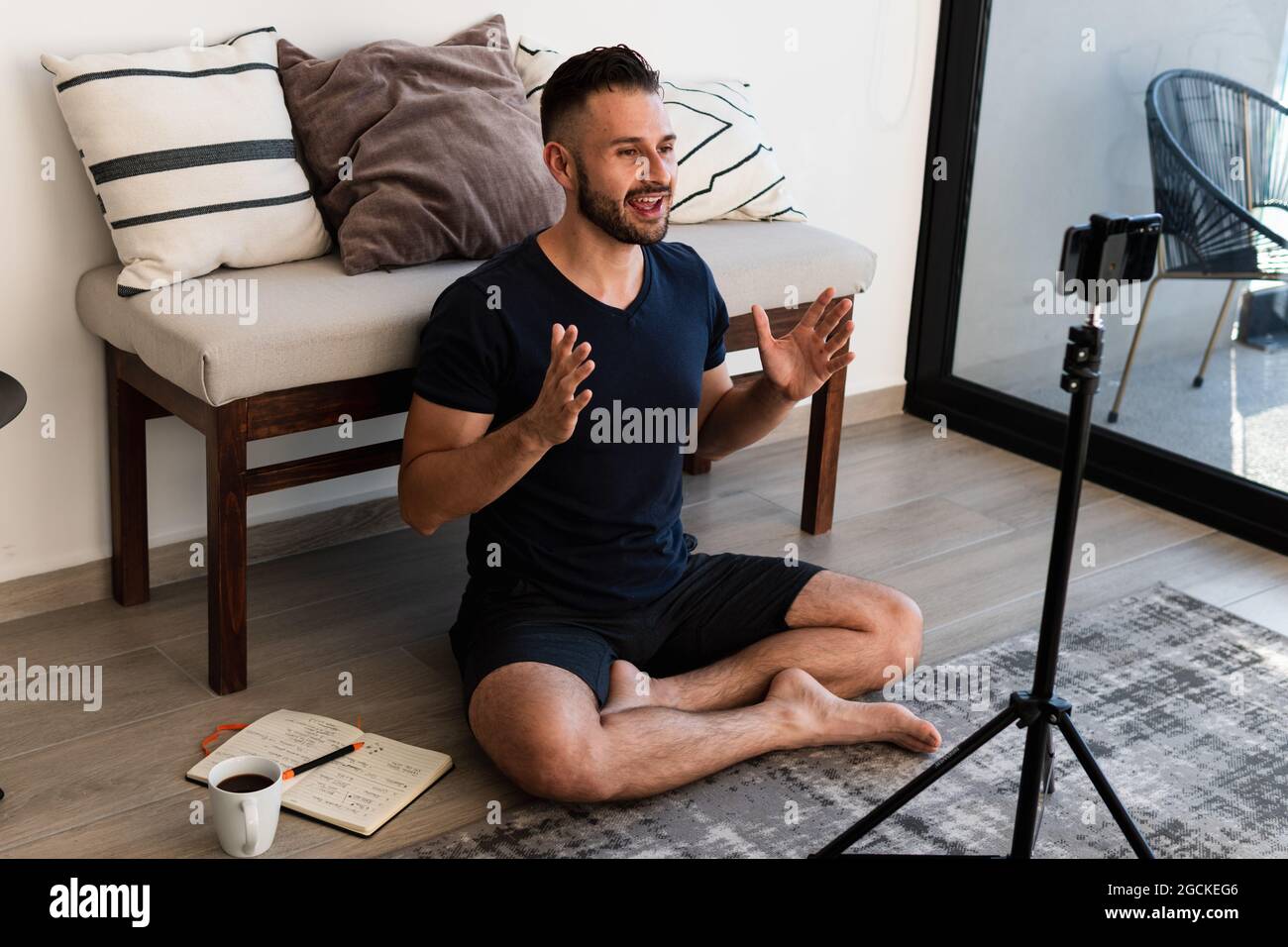 Vista laterale della giovane femmina in abbigliamento sportivo in piedi sulla testa con gambe sollevate durante la pratica yoga in estate Foto Stock