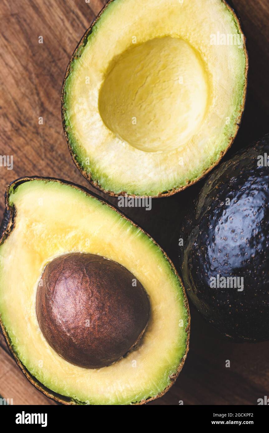 Halfs di asino di avocado su sfondo di legno. Foto Stock