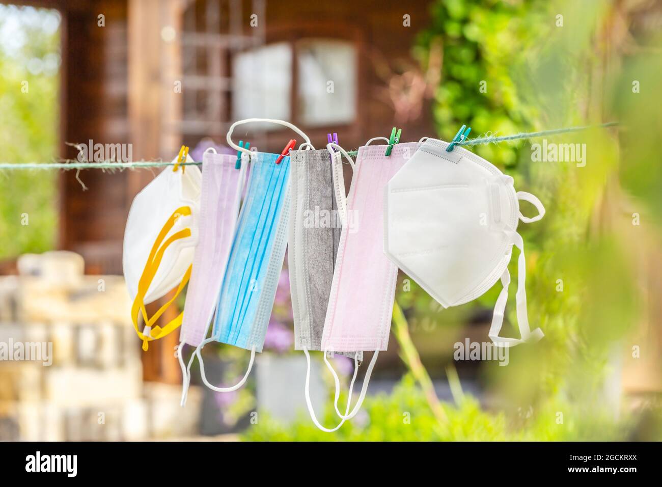 Un capoule di varie maschere di protezione del viso su una linea di vestiti all'aperto Foto Stock