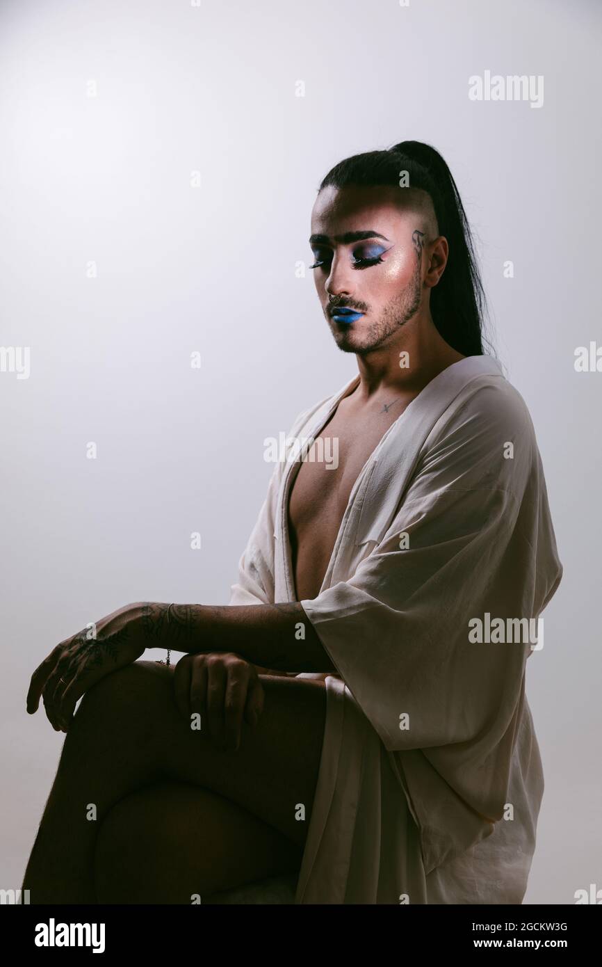 Ritratto di glamour transgender bearded Donna in sofisticato make con gli occhi chiusi su sfondo neutro Foto Stock