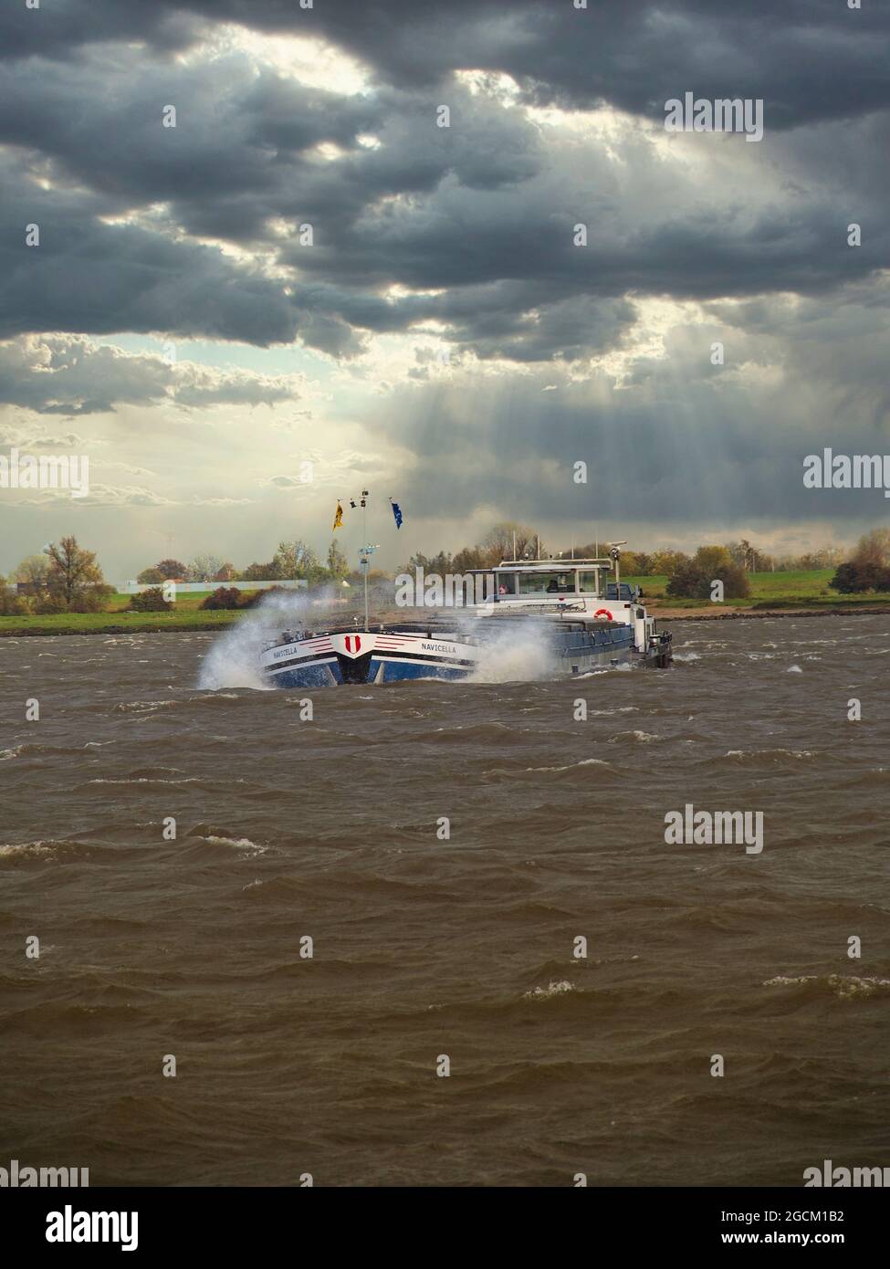 Trasporto commerciale sul fiume Reno in Germania sotto il cielo blu drammatico Foto Stock