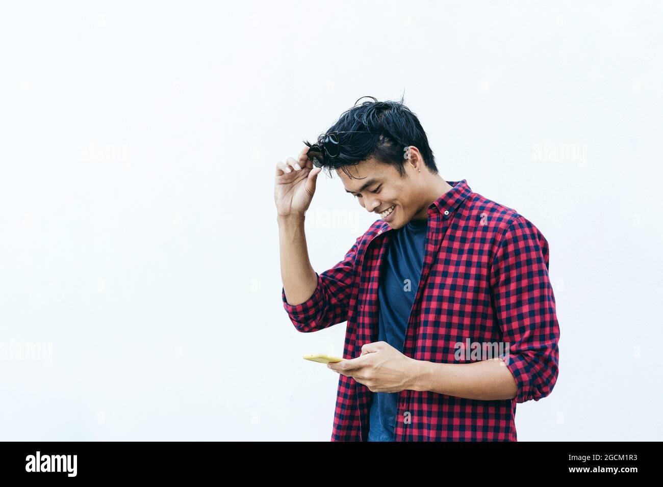 Happy asian Young man using mobile phone outdoor - Asian social influencer divertirsi con le nuove tendenze smartphone app - Generation z, media, technolog Foto Stock