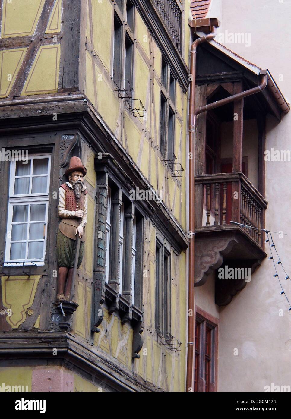 Primo piano di sculture di persone sul lato di edifici incorniciati in legno nella città tedesca di Breisach Foto Stock