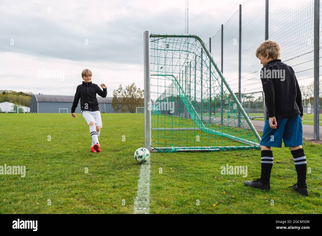 Ragazzi adolescenti in abbigliamento sportivo giocando a calcio insieme su  campo verde in estate Foto stock - Alamy