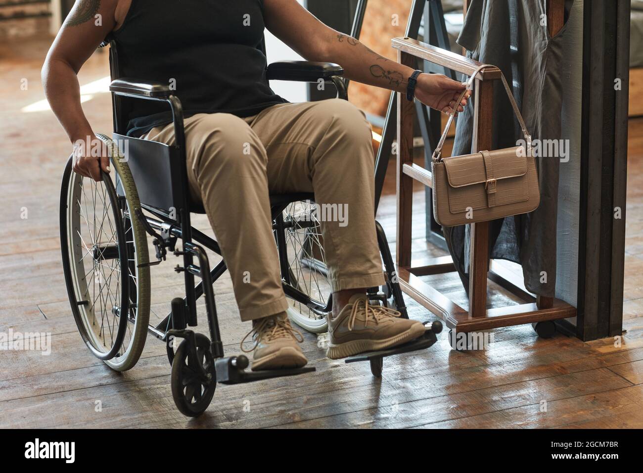 Un piccolo colpo di donna in sedia a rotelle che tiene la borsa mentre si è pronti per uscire, copia spazio Foto Stock