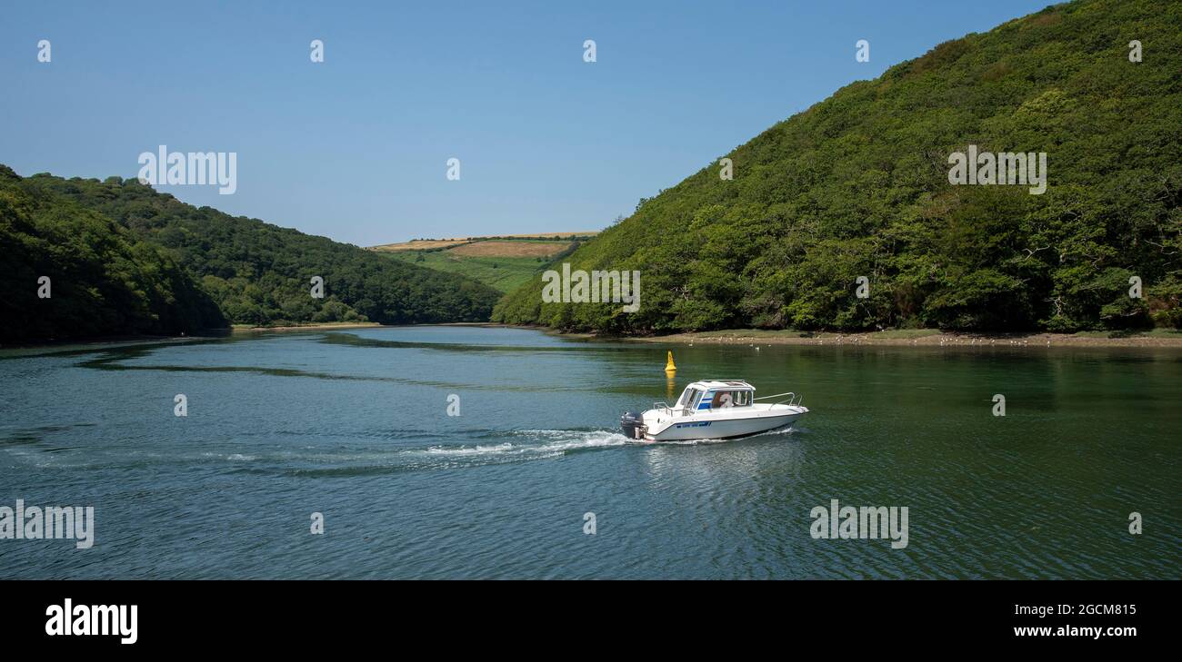 Looe, Cornovaglia, Inghilterra, Regno Unito. 2021. Una barca da giorno che si fa strada lungo il fiume West Looe, un fiume di marea che unisce il mare a Looe. Foto Stock