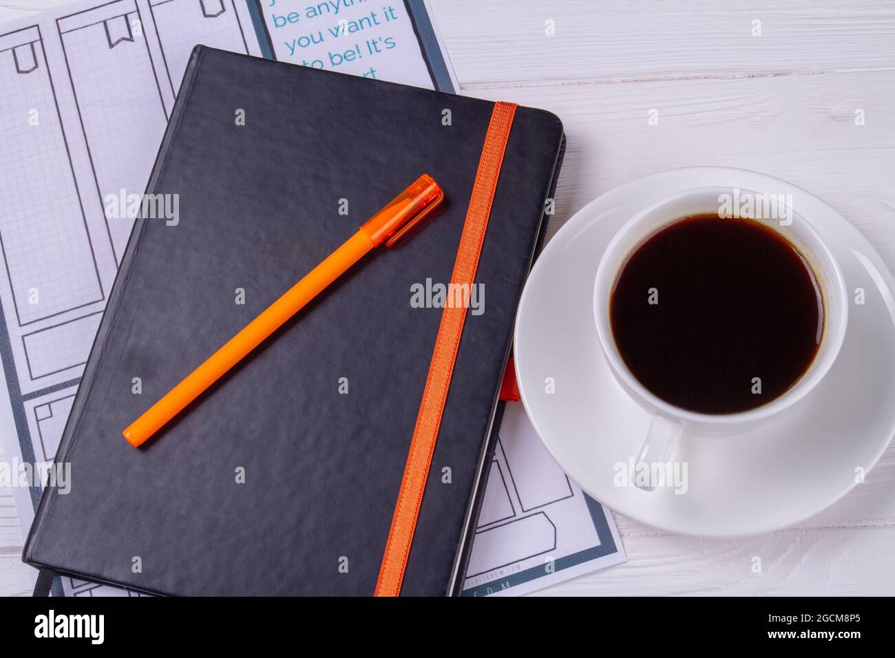 Tazza di caffè vista dall'alto con libro e penna. Foto Stock