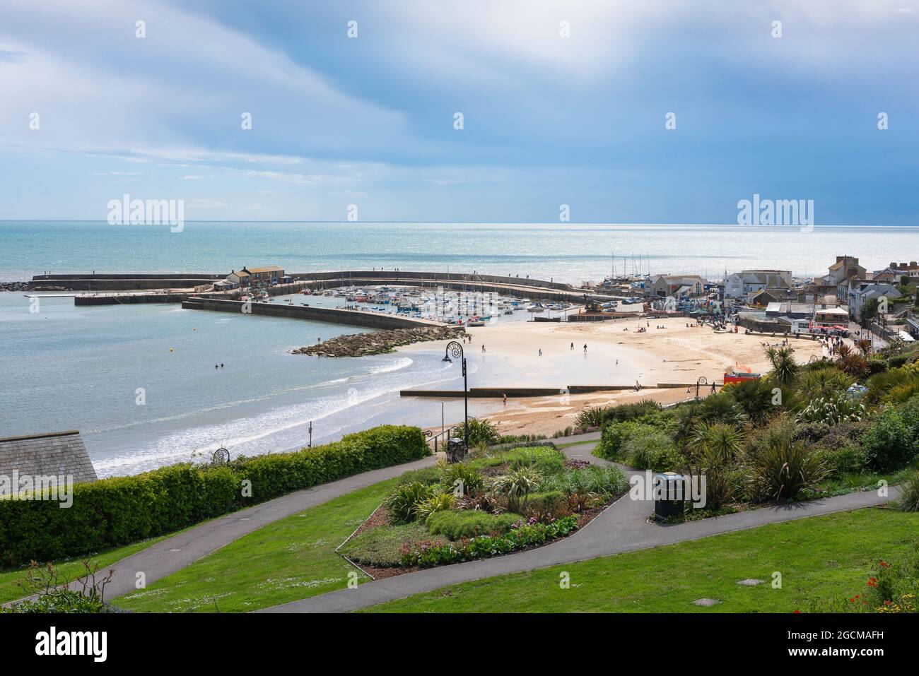 Lyme Regis, vista dall'interno del Langmoor e Lister Giardini di Lyme Regis spiaggia con il famoso muro COB visibile in lontananza, Dorset, Inghilterra, Regno Unito Foto Stock