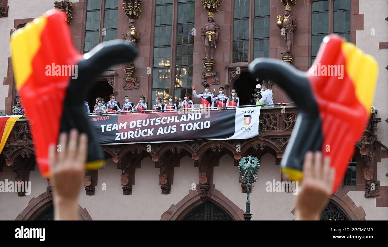 09 agosto 2021, Fráncfort: Gli atleti della squadra olimpica stanno sul balcone del Municipio di Francoforte durante la cerimonia di benvenuto per il Team Germany, dove un banner recita: 'Il Team Germany ritorna da Tokyo'. La Germania ha vinto la minor medaglia alle Olimpiadi di Tokyo del 2020 dalla riunificazione. Tuttavia, è finito nono nella tabella delle medaglie con 37 medaglie. Foto: Arne Dedert/dpa Foto Stock