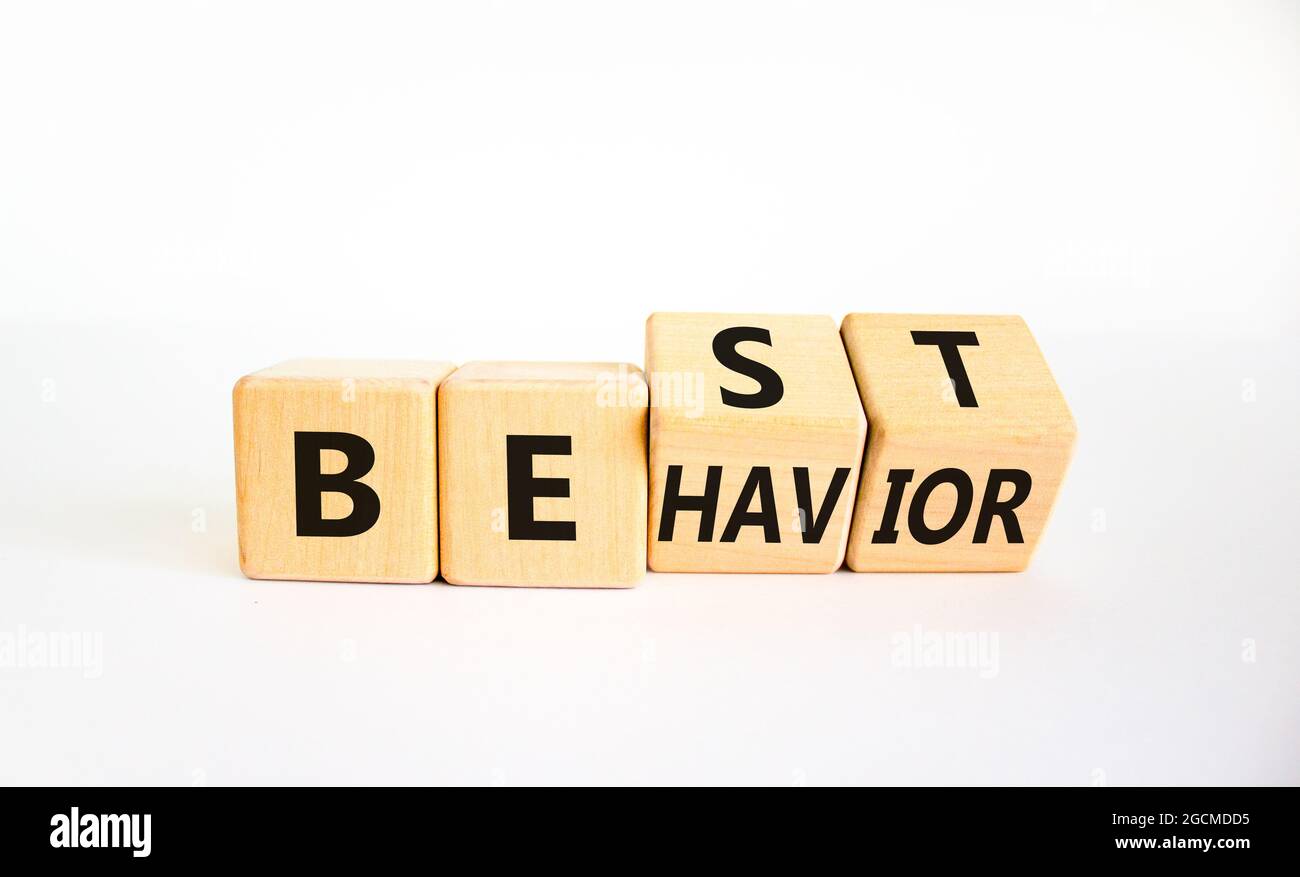 Simbolo del tempo per il miglior comportamento. Cubi di legno girati con le parole 'comportamento migliore'. Bel tavolo bianco, sfondo bianco, spazio copia. Psicologia, sana Foto Stock