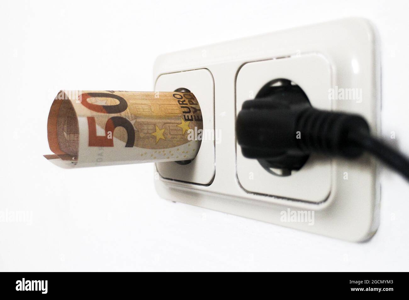 Una banconota in euro in una presa di corrente Foto Stock