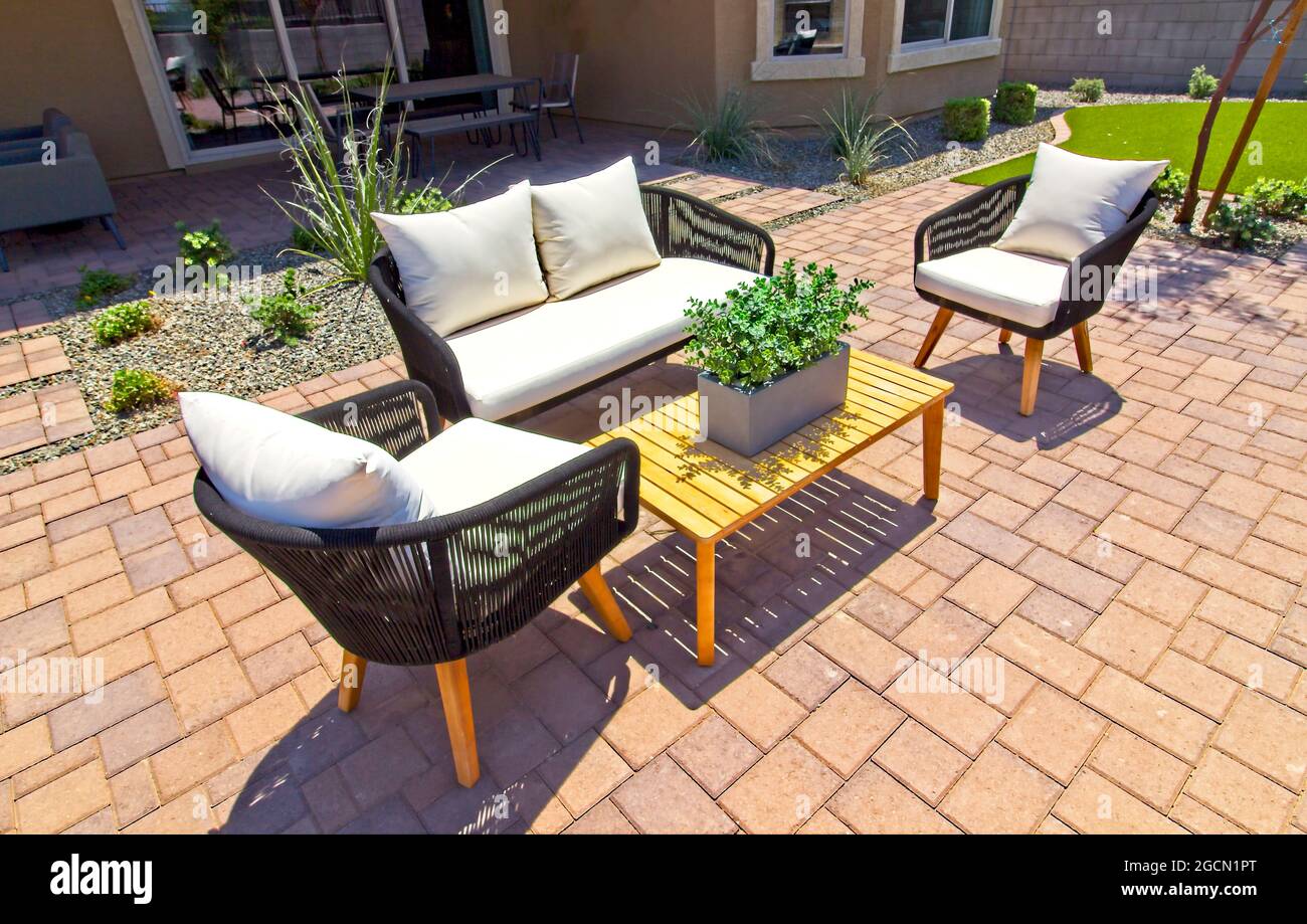 Patio posteriore Yard con sedie, divano e tavoli su asfaltatrici rosse Foto Stock