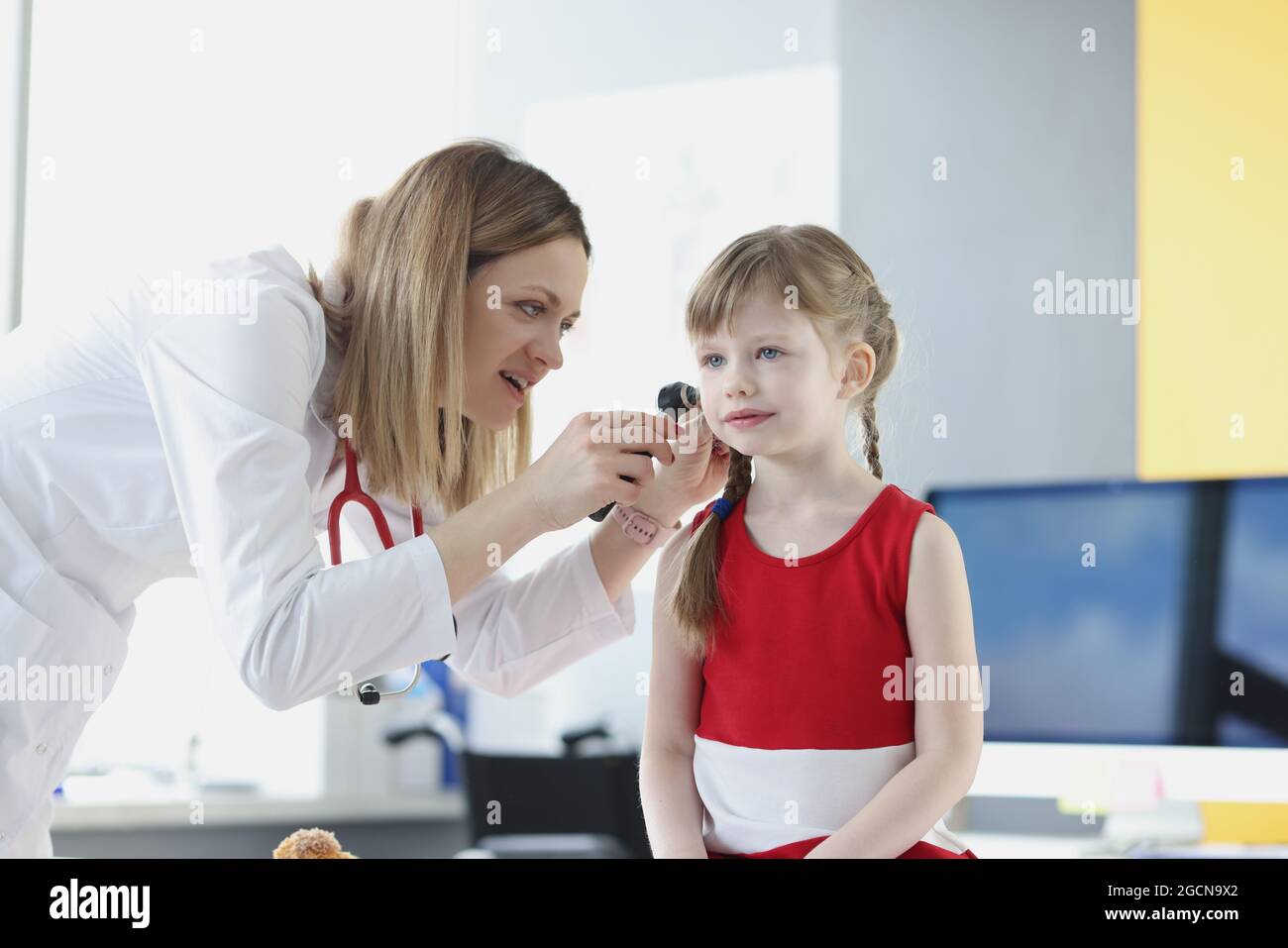 Il medico conduce l'esame medico dell'orecchio della bambina Foto Stock