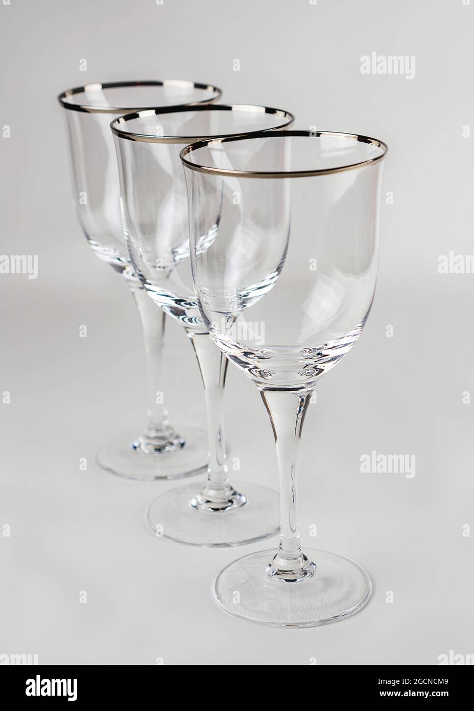 Tre bicchieri da vino vuoti in fila su sfondo bianco. Foto Stock