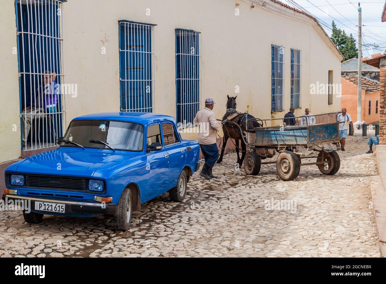 TRINIDAD, CUBA - 8 FEBBRAIO 2016: Macchina sovietica Lada e una carrozza a cavallo su una strada acciottolata nel centro di Trinidad, Cuba. Foto Stock