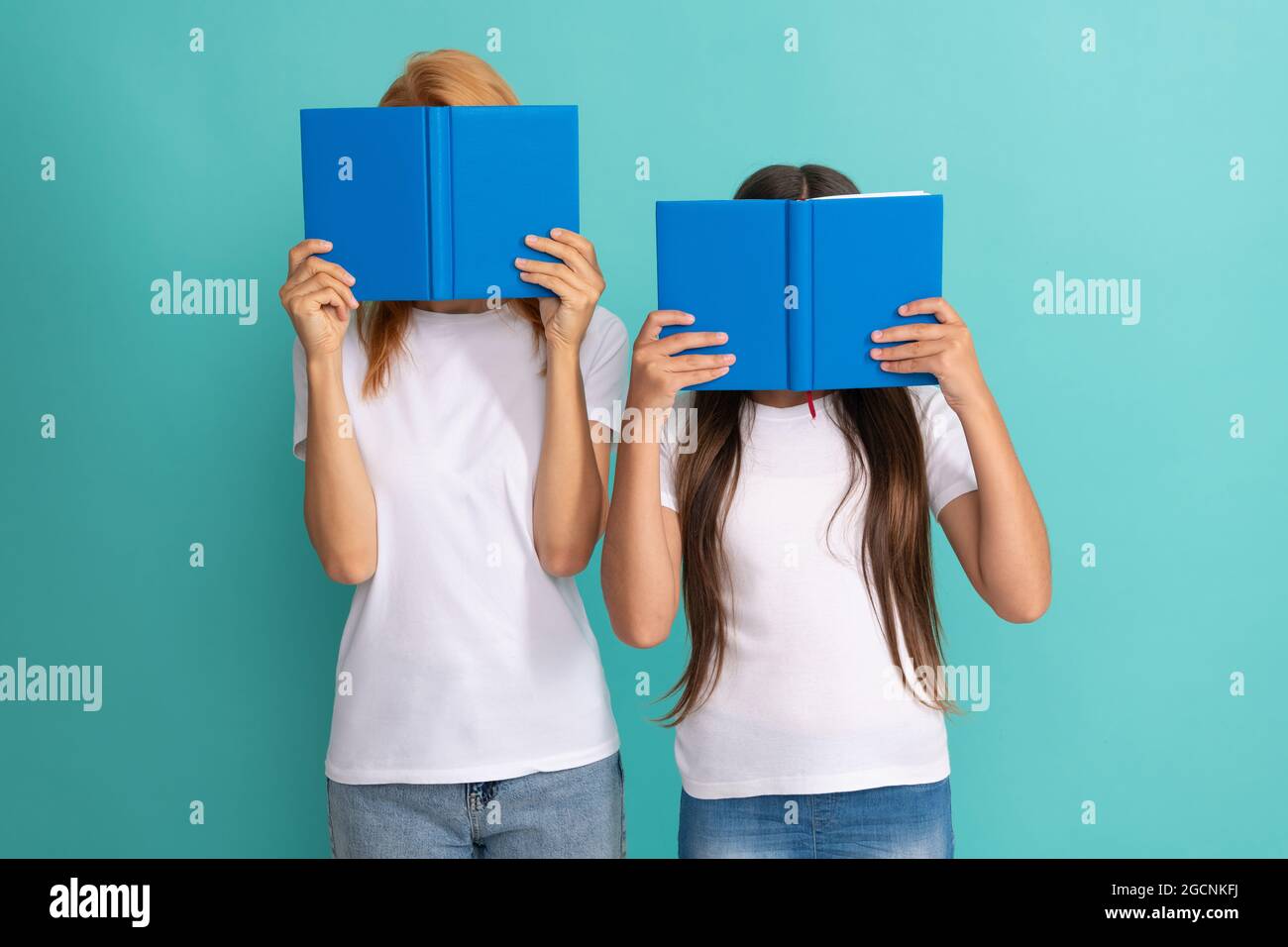madre e figlia si nascondono dietro libri pronti a studiare, letteratura Foto Stock