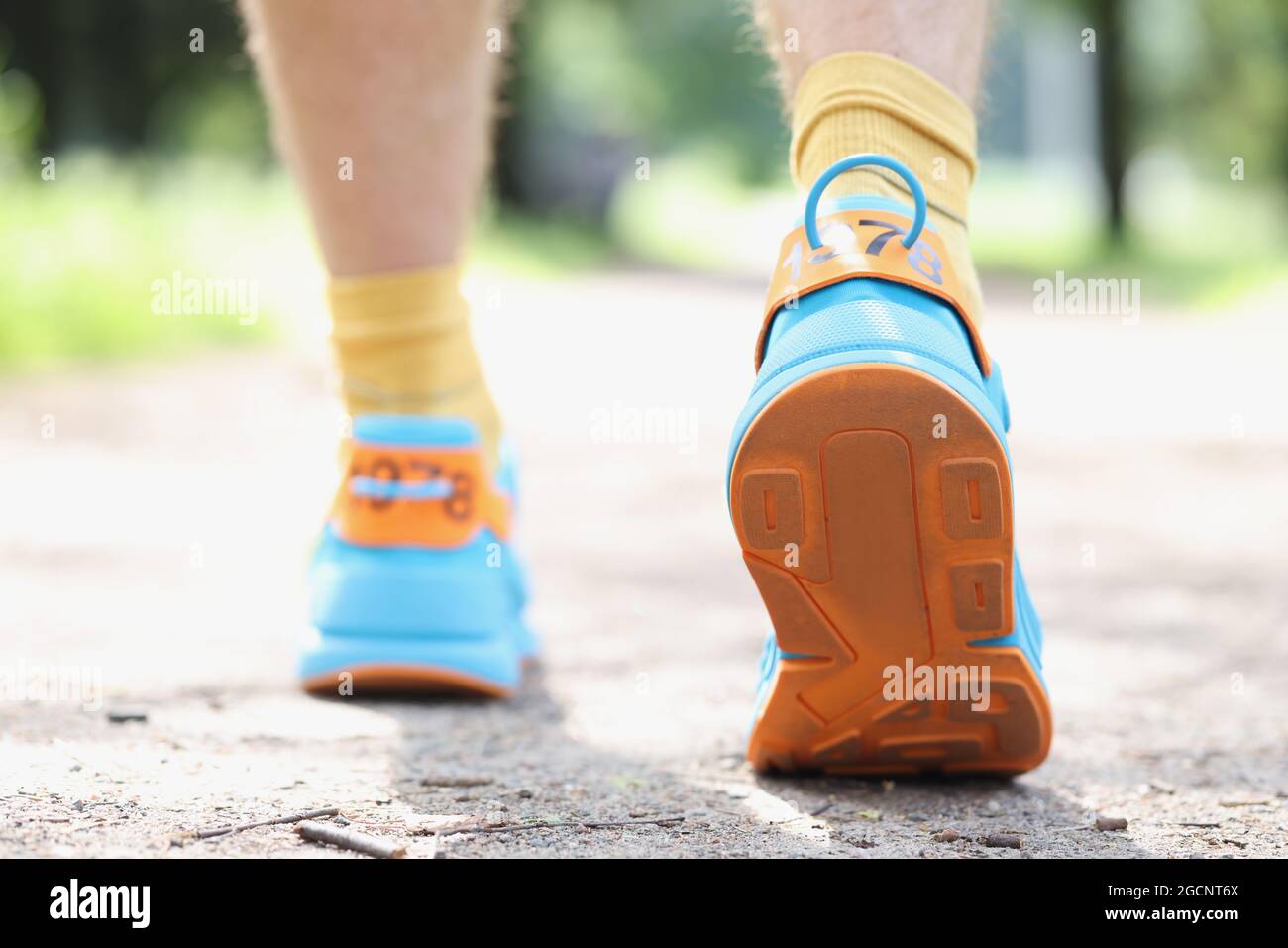 Gambe di runner maschili sportive pronte per essere eseguite sulla pista forestale closeup Foto Stock