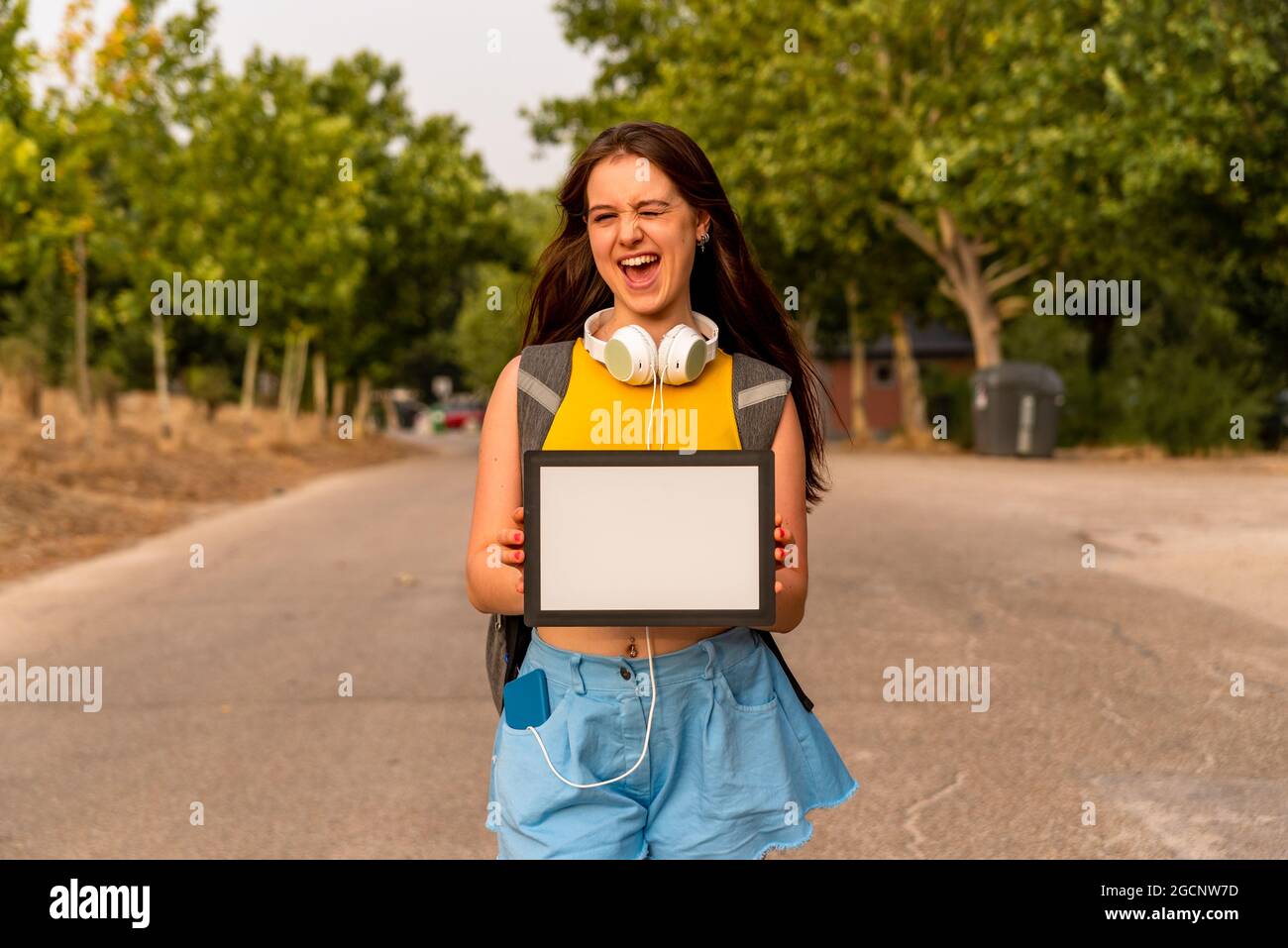 Giovane caucasica che mostra una lavagna vuota nel parco Foto Stock