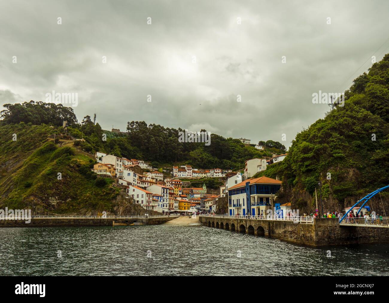 Cudillero, Asturie, Spagna: Vista panoramica di case colorate situate su una scogliera che si affaccia sul piccolo porto di pescatori catturato nel giorno delle piogge. Foto Stock