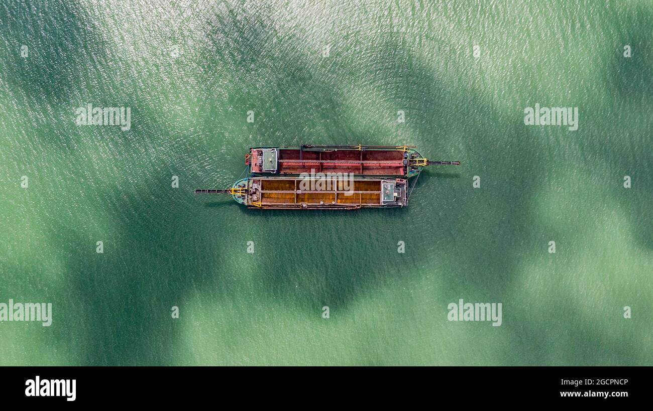 Vecchie barche da pesca sul mare al largo della costa della Malesia dal cielo. Vista aerea di due vecchie barche di pescatori malesi in legno sul fiume Lebam vicino al Foto Stock