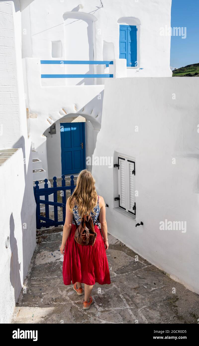 Case bianche e blu delle Cicladi, giovane donna con abito rosso nel centro storico di Lefkes, Paros, Cicladi, Grecia Foto Stock
