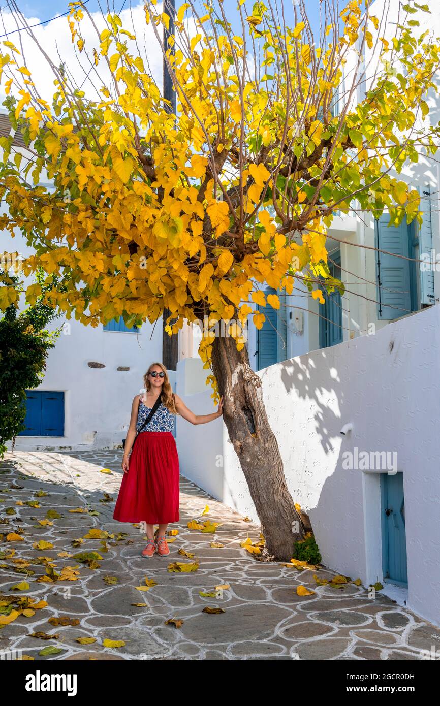 Giovane donna con abito rosso nel centro storico di Lefkes, Paros, Cicladi, Grecia Foto Stock