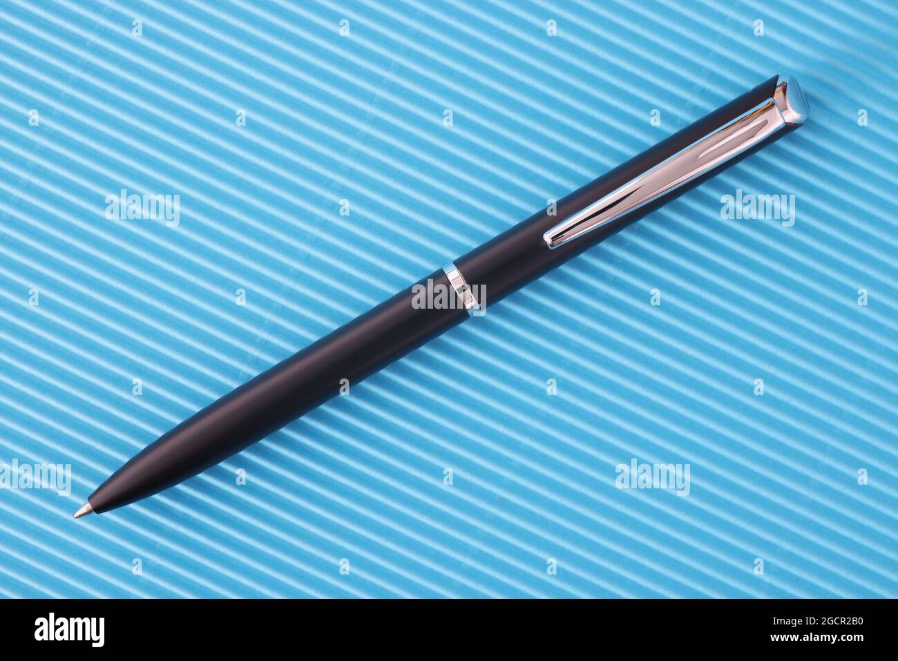 Penna a sfera classica nera su sfondo blu Foto Stock