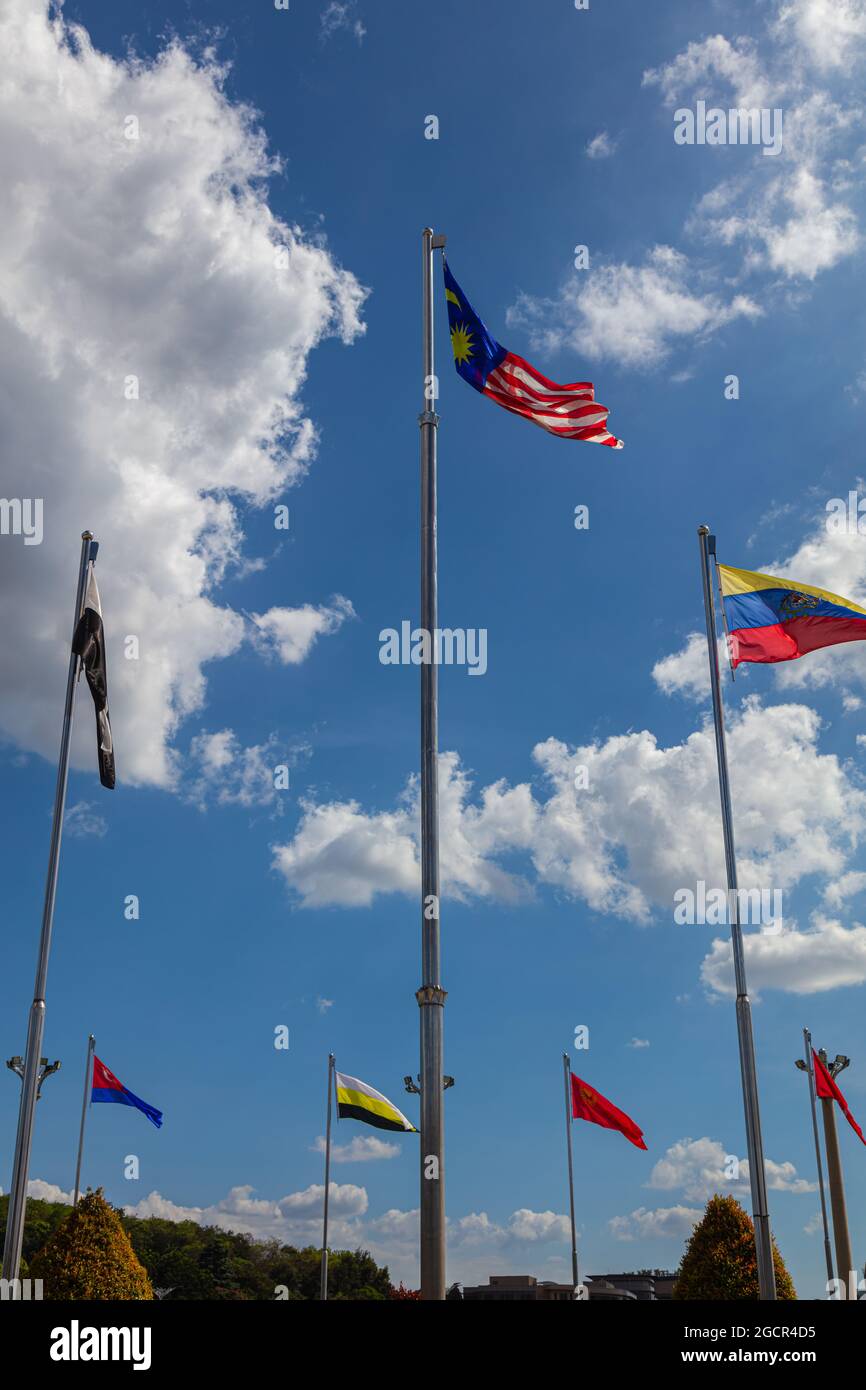 La bandiera nazionale della Malesia, circondata dalle bandiere degli stati malesi. Catturato in Piazza Putra a Putrajaya, Malesia. Nuvole bianche Foto Stock