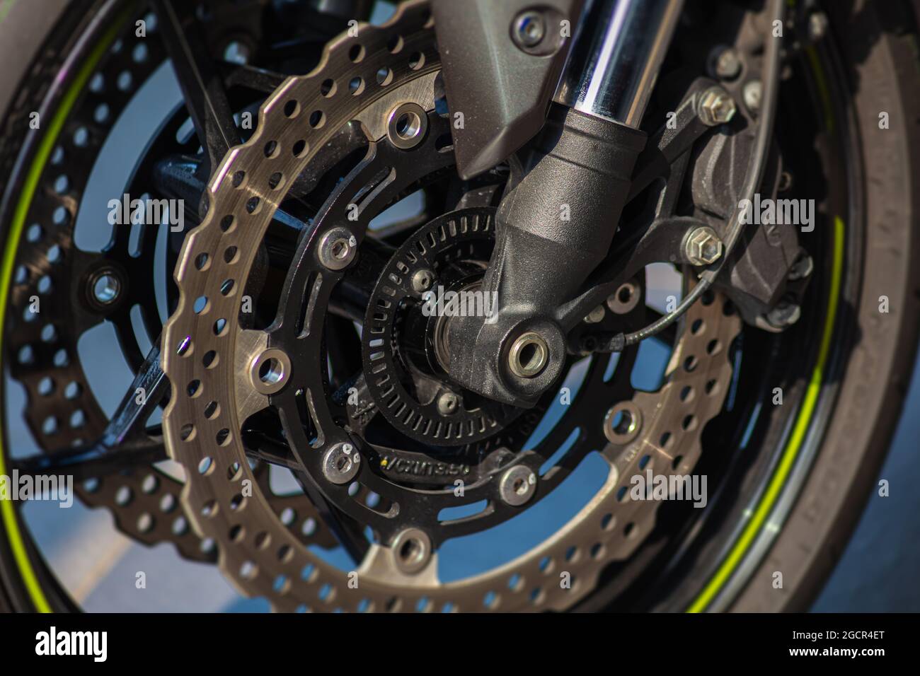 Avvicinati alla rottura del disco di una motocicletta. Il sistema di rottura di una moto super veloce forte. Fotografia macro della ruota anteriore di una moto Foto Stock