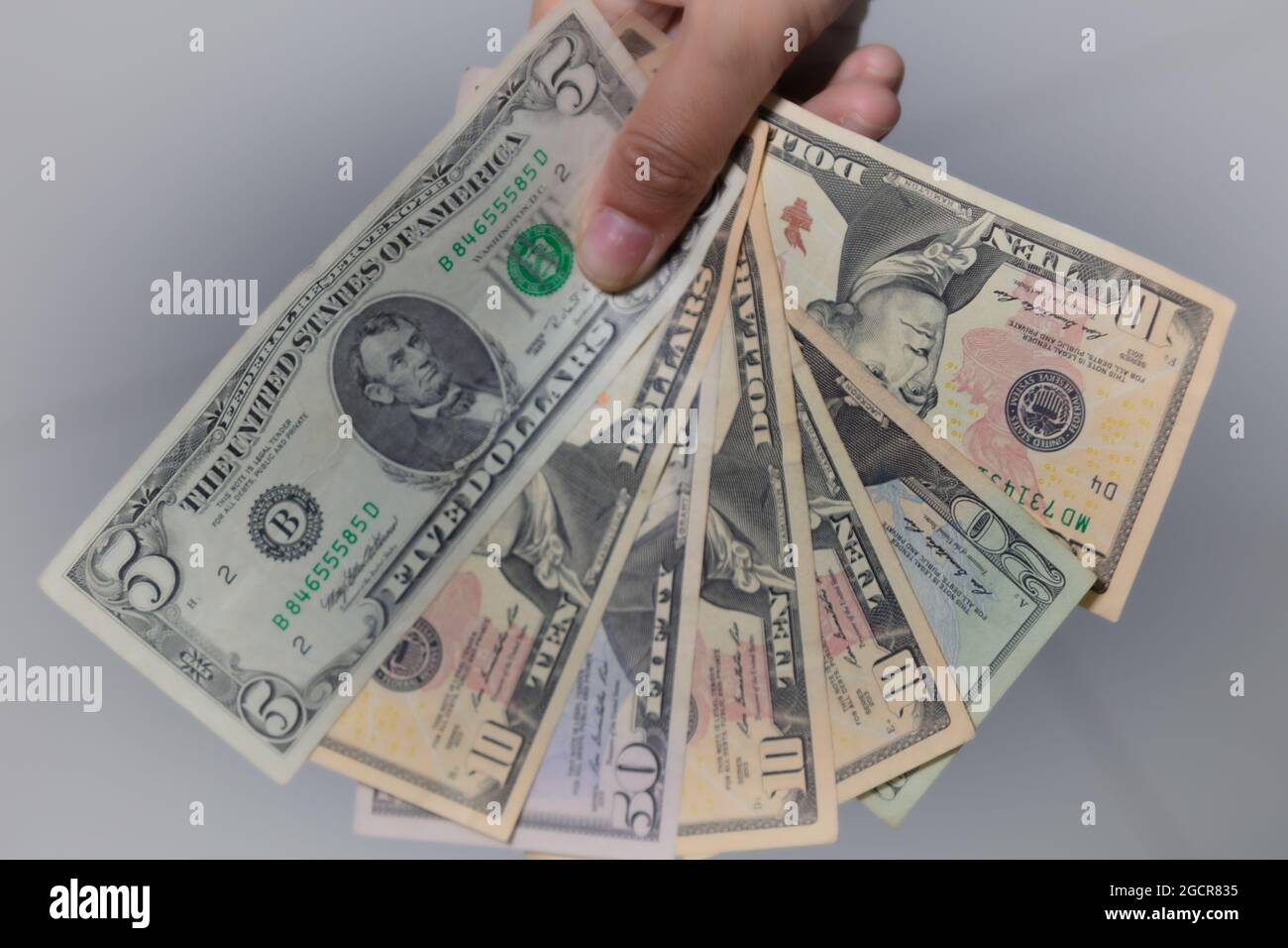 Una raccolta di dollari americani in una mano femminile, un po 'di soldi tascabili. La mano della donna mostra le banconote in dollari USA. Le mani delle ragazze tengono i soldi degli Stati Uniti. Curr. Mondiale Foto Stock
