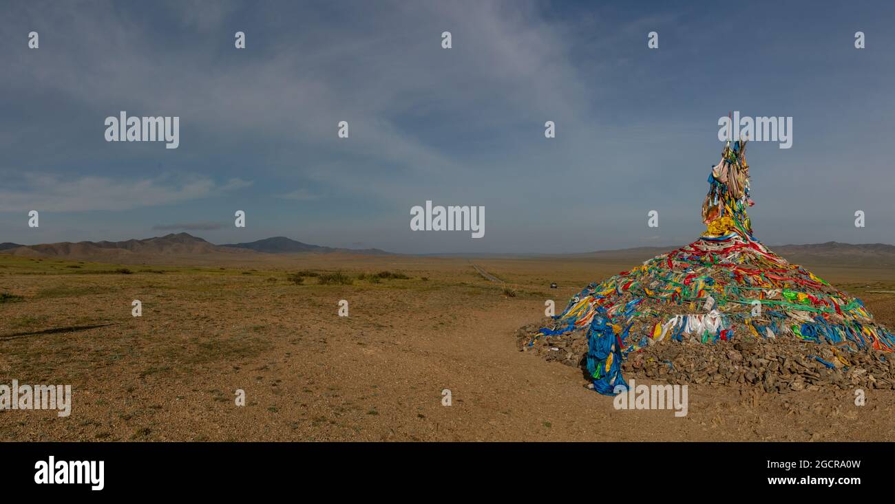 Mongolia centrale, vicino a Karakorum, Ovoo, pietra di preghiera di tumulo di pietra con bandiere di preghiera colorate. Il bellissimo paesaggio della Mongolia. Ovoo, mucchio di pietre Foto Stock