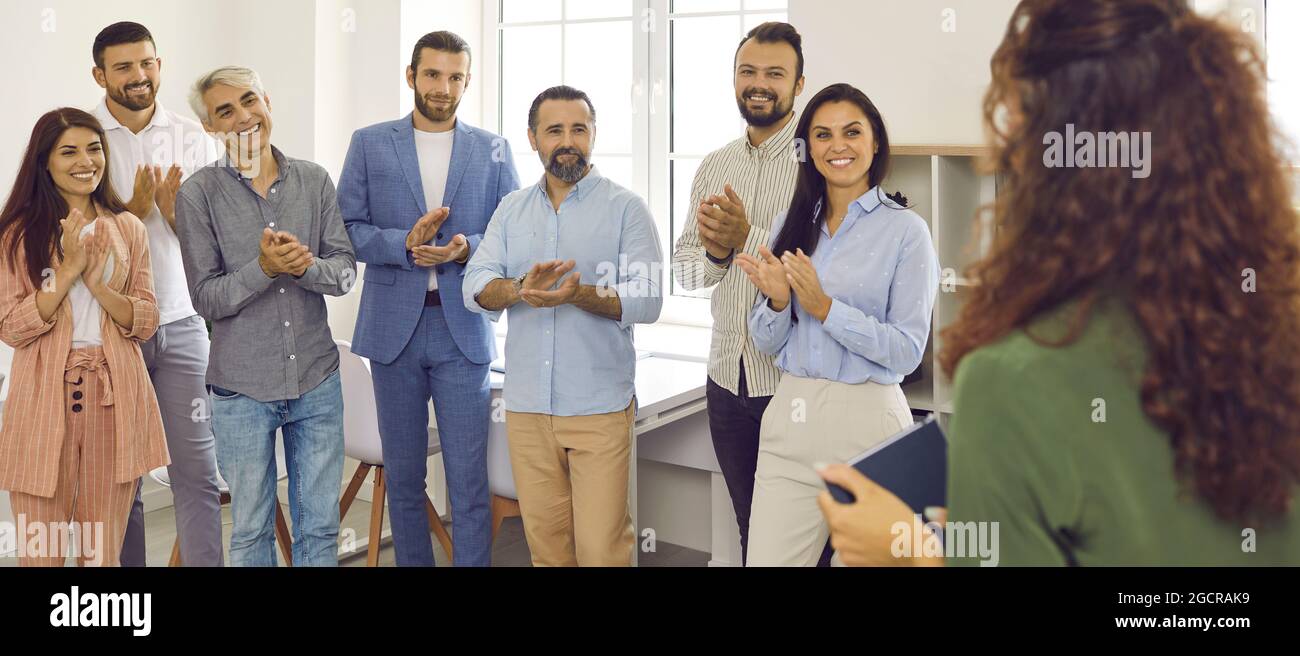 Pubblico felice in ufficio e applaudente oratore aziendale per la presentazione Foto Stock