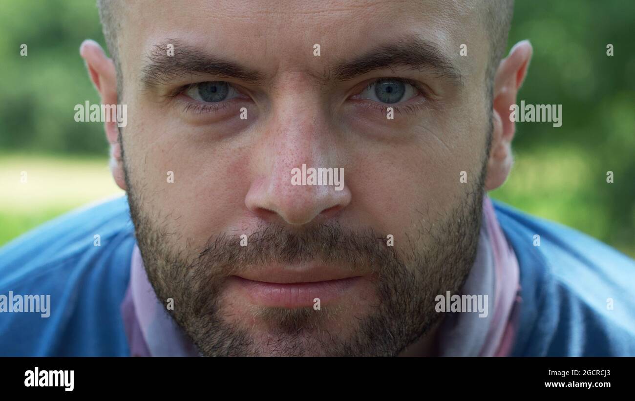 Lo sguardo di un uomo bianco. Verticale, primo piano. Un uomo con una stoppia sul viso. Foto Stock