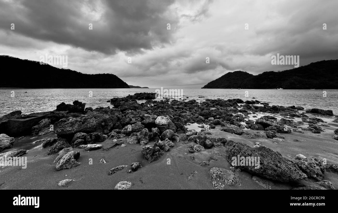 Rocce sulla spiaggia di la Primavera, Filippine. Spiaggia di pietra in una giornata nuvolosa nella laguna. Il riff nella baia con il bianco e nero grandangolo vi Foto Stock