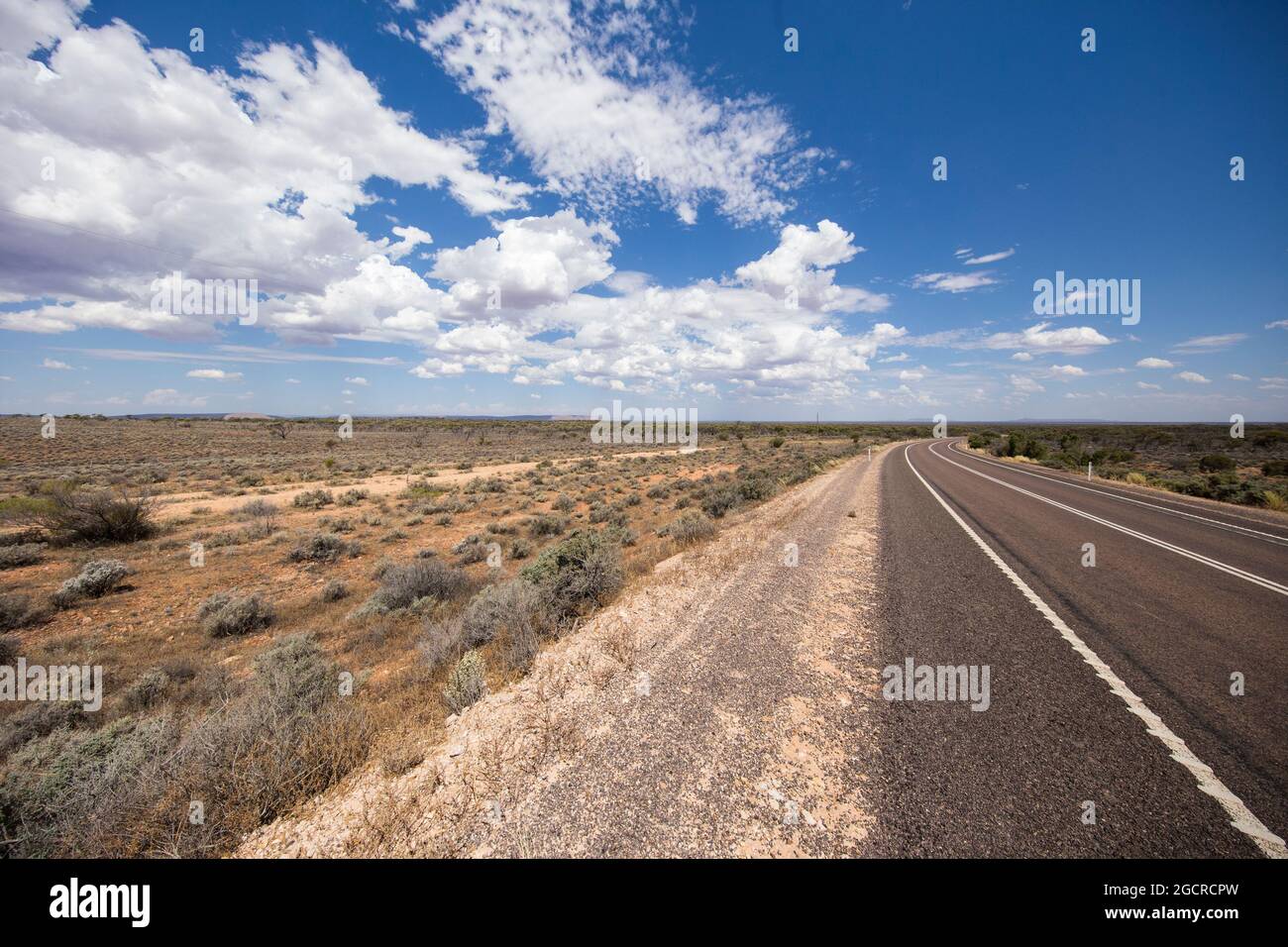 La strada per nessun posto all'Australian Outback. L'autostrada stuart sulla strada per Uluru o Ayers Rock. Via vuota attraverso l'ampio piano aperto austr Foto Stock