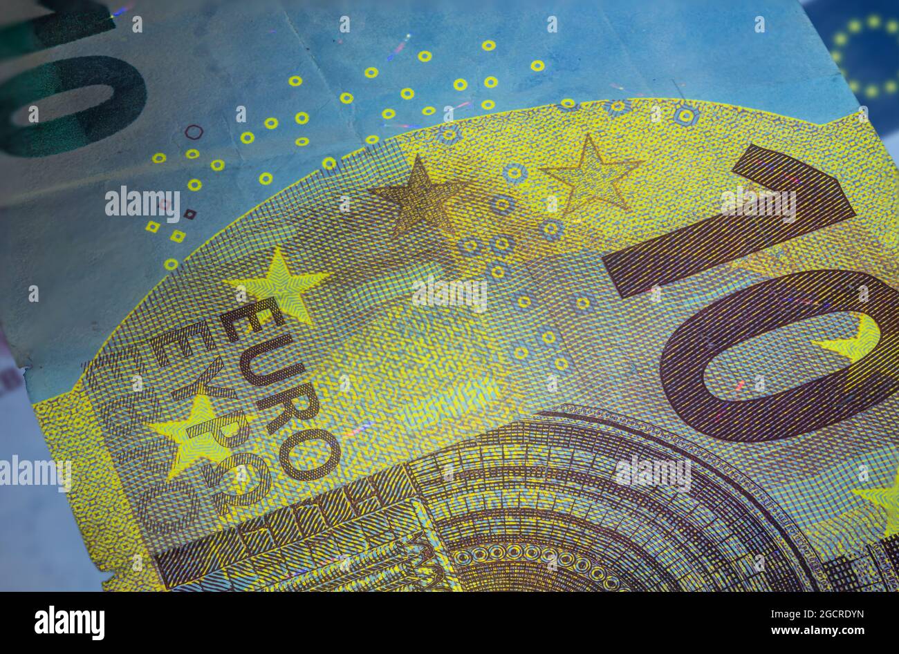 Banconota da dieci Euro sotto luce UV fluorescente. Immagine macro in primo piano del denaro europeo illuminata con luce Fluor. Carta moneta del centro europeo Foto Stock