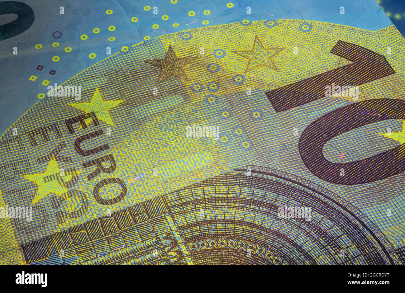 Banconota da dieci Euro sotto luce UV fluorescente. Immagine macro in primo piano del denaro europeo illuminata con luce Fluor. Carta moneta del centro europeo Foto Stock