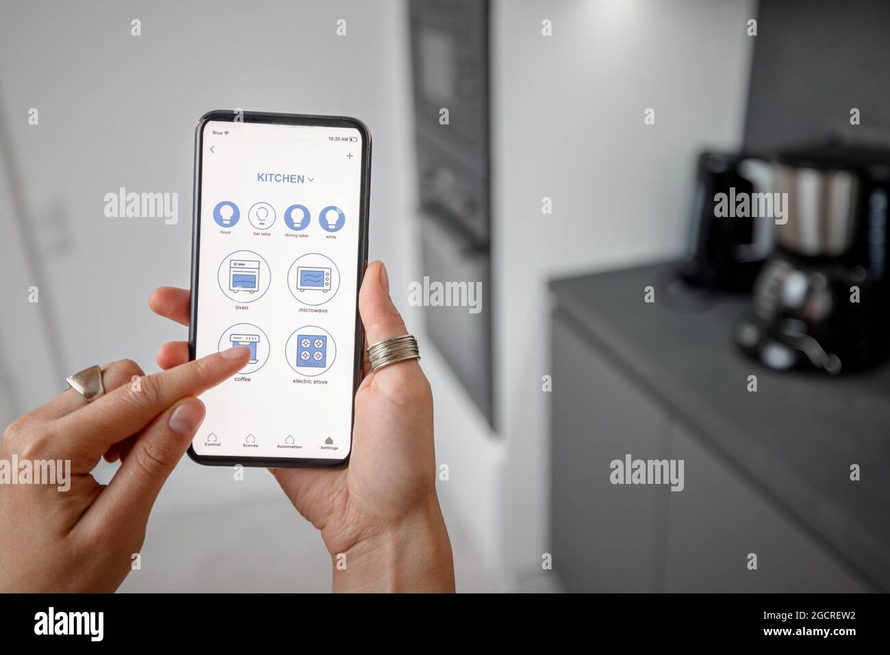 Controllo dei dispositivi intelligenti con il telefono in cucina Foto Stock