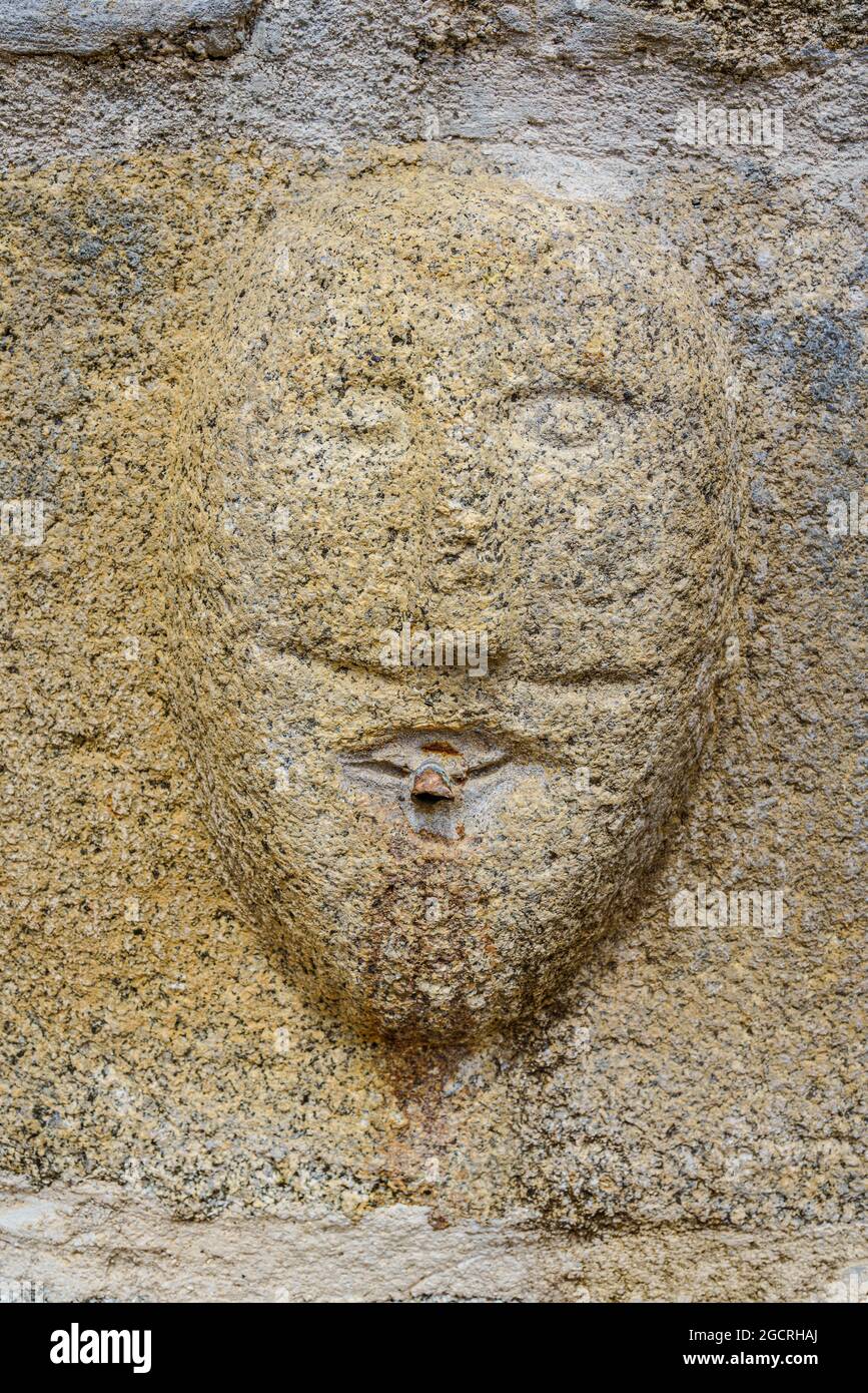 Llivia, Spagna. 2 agosto 2021. Faccia scolpita su pietra di granito nella chiesa di nostra Signora degli Angeli. Tempio romanico e gotico. Foto Stock